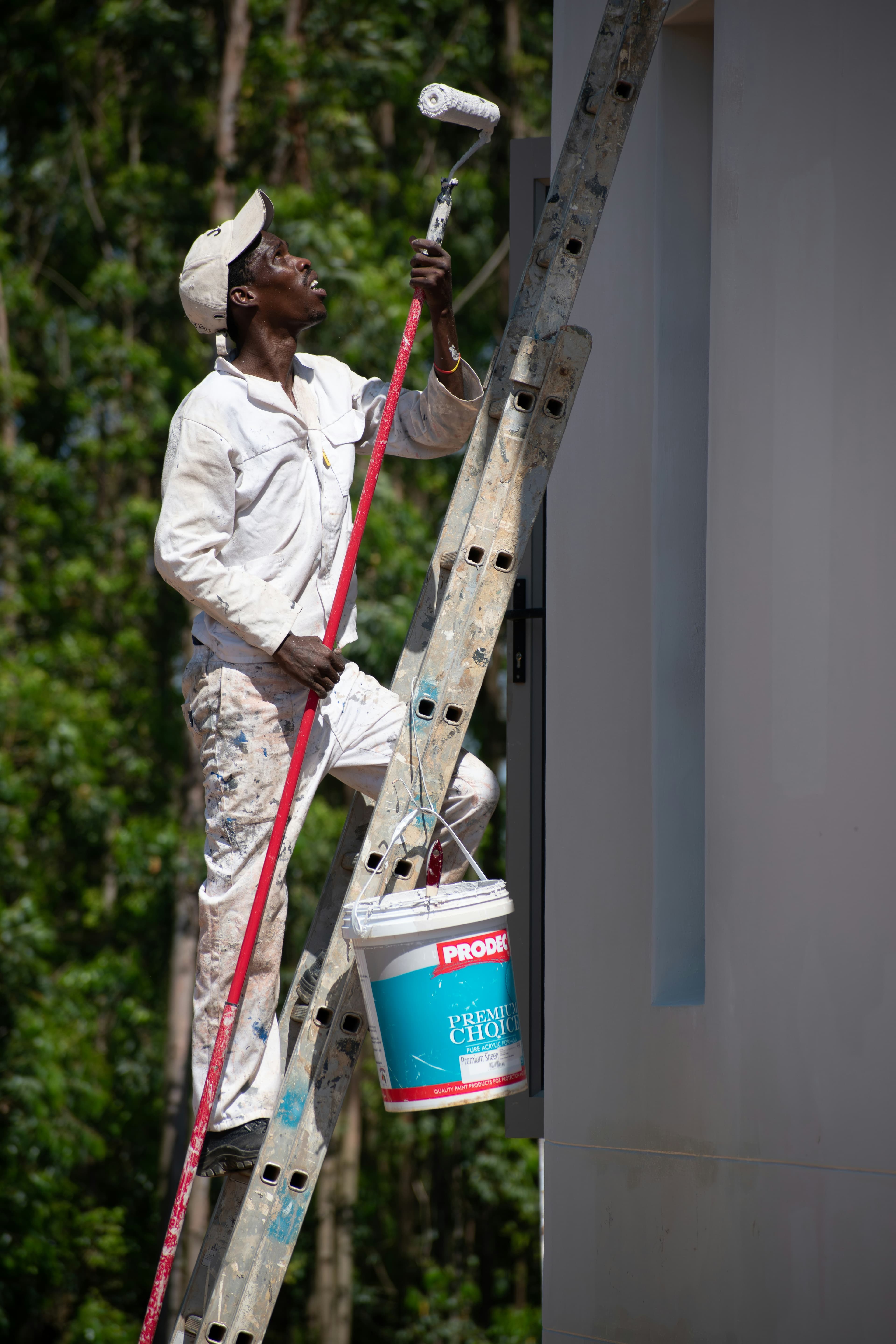 A South African painter working on a ladder outside a home